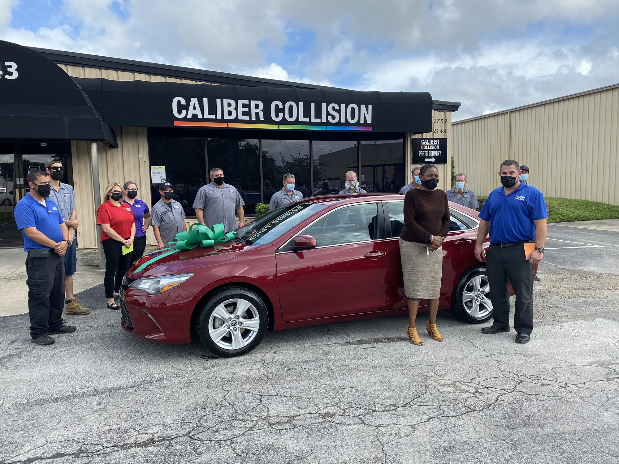 The happy recipient and the Caliber Collision team at an NABC Recycled Ride giveaway event.